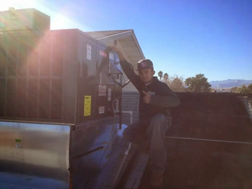 HVAC technician performing AC Tune-Up on a rooftop unit in Taylors